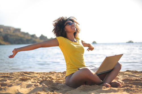 Picture of a women on a beach who is showing that she is happy and single.