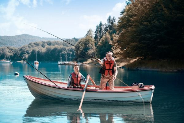 Image of two men fishing in a boat in middle of lake
